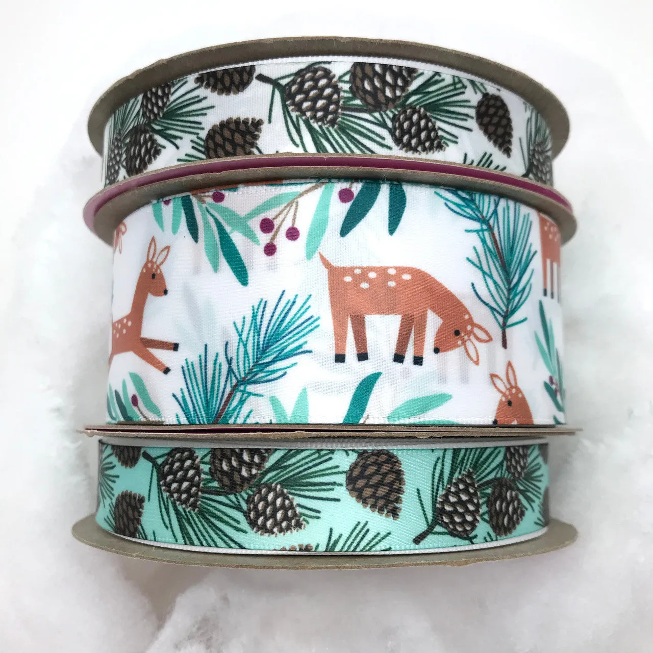 Pine cones ribbon with branches and needles on a light green background printed on 5/8" white single face satin